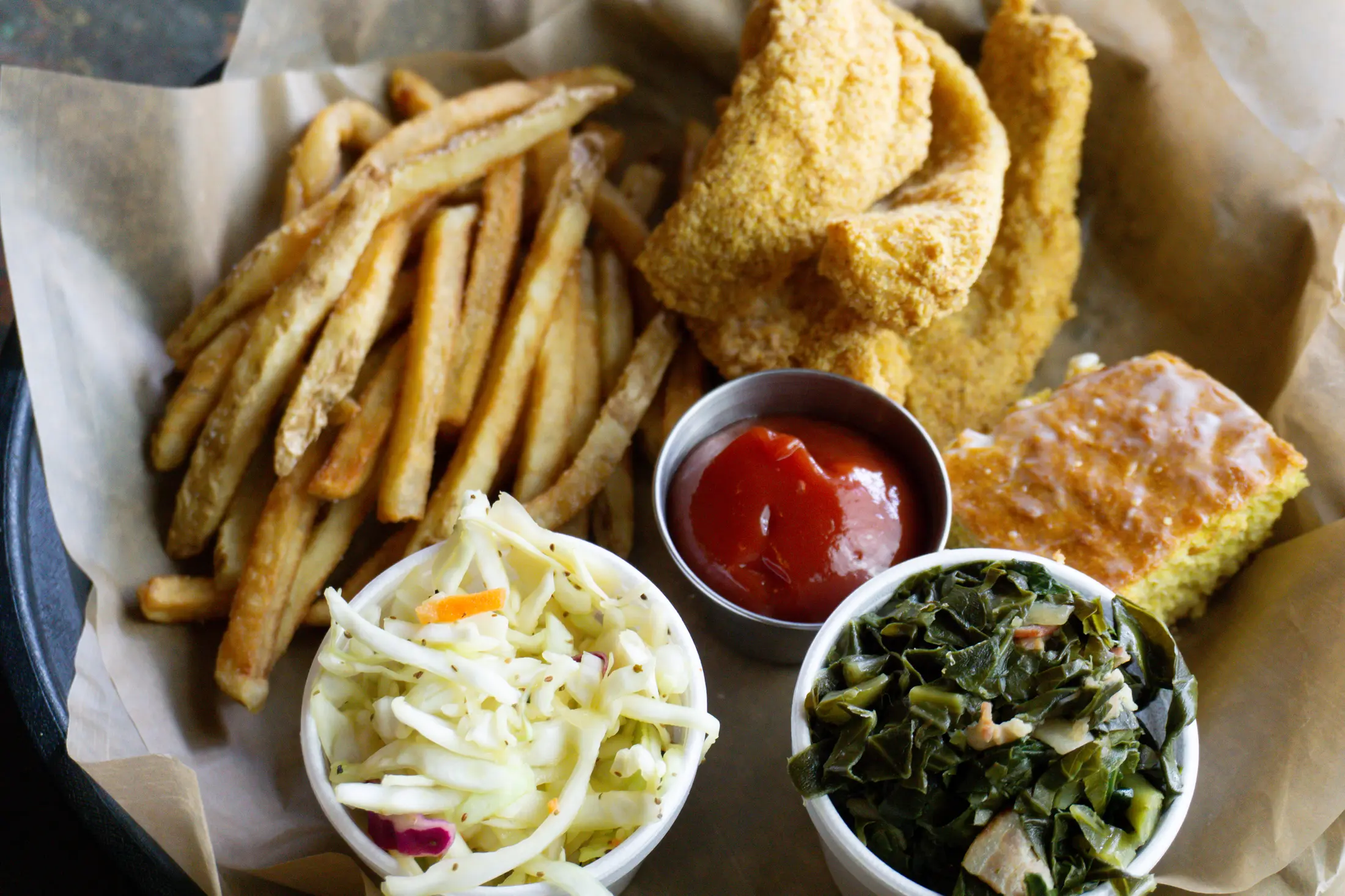 Lamon’s fried catfish plate with fries, slaw, greens, cornbread, and sauce